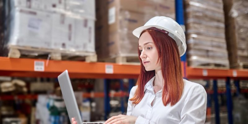 mujer-casco-tenencia-abierto-computador-portatil-trabajando